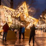 Das Bild zeigt einen großen, begehbaren und illuminiereten Weihnachtssterm in der Fußgängerzone von Bremerhaven. Menschen machen Fotos von sich und dem Stern.