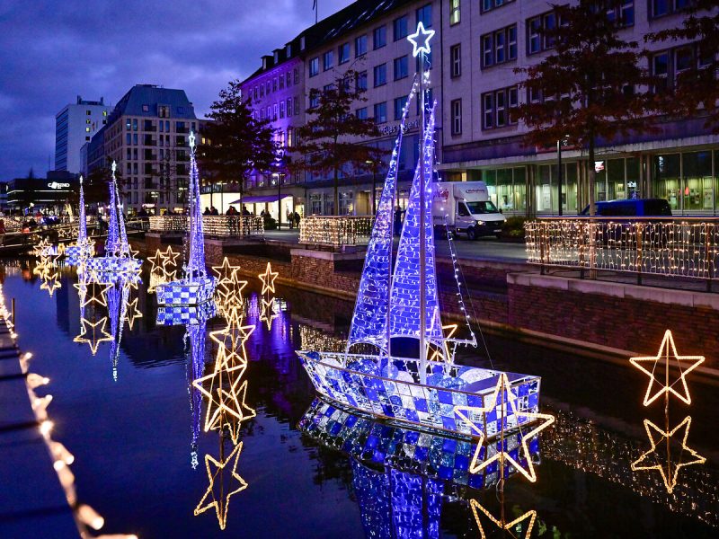 Das Bild zeigt Segelboote und Sterne als Lichtskulpturen im Wasser