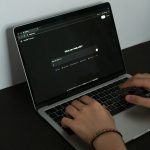 Das Bild zeigt einen Laptop auf einem Schreibtisch, jemand gibt einen Prompt ein.