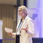 Anja Karliczek als Rednerin mit Handzettel und einem Mikrofon auf der Bühne beim NordseeTourismusTag 2026 in Leer