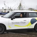 Gewinnerin des Gewinnspiels zum Nordsee-Flitzer bei der Übergabe des BMWs in dem neuen Auto.